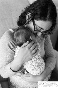 Littleton family photographer black and white mother son snuggles newborn new baby in home lifestyle photo session Colorado photography nursery comfort bonding