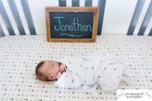 Littleton family photographer crib newborn new baby boy Jonathan swaddled sleeping content Colorado in home lifestyle session photo photos photography sign chalkboard nursery