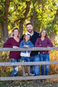 Littleton family photographer in Colorado at Hildebrand Ranch fall leaves wooden fence wood girls sisters tween girl