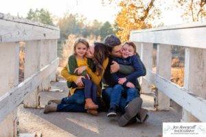 Littleton family photographer in Colorado at Writer's Vista park Centennial Highline Trail fall leaves golden hour sunset light big brother little sister kids children natural smiles real life parenthood bridge snuggles kisses with Mom and Dad