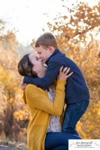 Littleton family photographer in Colorado at Writer's Vista park Centennial Highline Trail fall leaves golden hour sunset light big brother little sister kids children natural smiles real life parenthood mother son snuggles and kisses