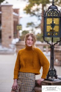 Littlleton family photographer Highlands Ranch Mansion stone building winter snow fall leaves red barn old building metal gate sisters big little girls teen teenagers foothills view at sunset