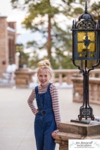 Littlleton family photographer Highlands Ranch Mansion stone building winter snow fall leaves red barn old building metal gate sisters big little girls teen teenagers foothills view at sunset