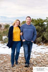 Littlleton family photographer Highlands Ranch Mansion stone building winter snow fall leaves red barn old building metal gate sisters big little girls teen teenagers foothills view at sunset