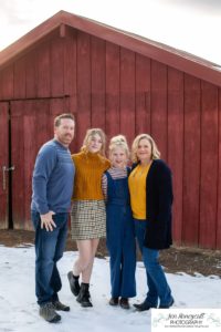 Littlleton family photographer Highlands Ranch Mansion stone building winter snow fall leaves red barn old building metal gate sisters big little girls teen teenagers foothills view at sunset