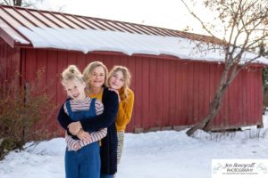 Littlleton family photographer Highlands Ranch Mansion stone building winter snow fall leaves red barn old building metal gate sisters big little girls teen teenagers foothills view at sunset daughters