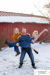 Littlleton family photographer Highlands Ranch Mansion stone building winter snow fall leaves red barn old building metal gate sisters big little girls teen teenagers foothills view at sunset daughters