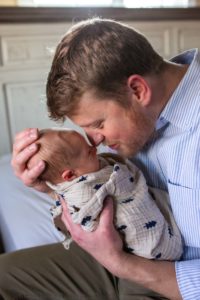Littleton family photographer newborn new baby photography in home lifestyle photo session boy infant tiny love swaddled son father