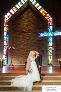 Littleton wedding photographer in Colorado at Cherry Hills Community church Highlands Ranch foothills Christ centered Christian bride groom husband wife married marriage love getting ready long white dress tuxedo bridesmaids groomsmen winter reception young college father mother son daughter stained glass beautiful ring suspenders navy blue pretty flowers