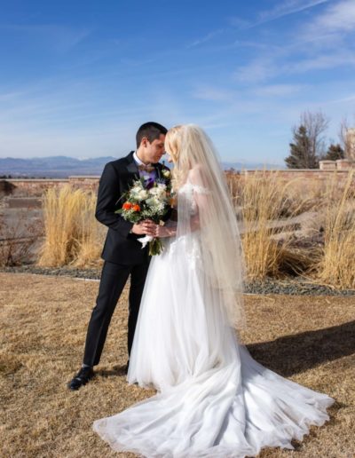 Littleton wedding photographer in Colorado at Cherry Hills Community church Highlands Ranch foothills Christ centered Christian bride groom husband wife married marriage love getting ready long white dress tuxedo bridesmaids groomsmen winter reception young college father mother son daughter stained glass beautiful ring suspenders navy blue pretty flowers