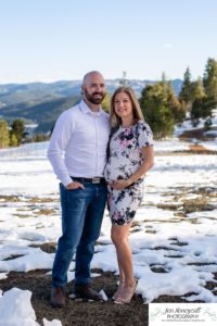 Littleton family maternity photographer in Colorado Mt. Falcon park snow spring baby bump pregnant husband and wife mountain view mountains foothills sunset natural golden light