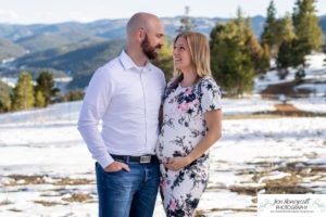 Littleton family maternity photographer in Colorado Mt. Falcon park snow spring baby bump pregnant husband and wife mountain view mountains foothills sunset natural golden light