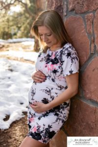 Littleton family maternity photographer in Colorado Mt. Falcon park snow spring baby bump pregnant husband and wife mountain view mountains foothills sunset natural golden light