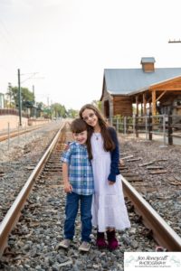 Littleton family photographer in Colorado Olde Town Arvada main street urban flour mill railroad tracks boy girl sister brother siblings mother father son daughter Halloween costume dinosaur zombie