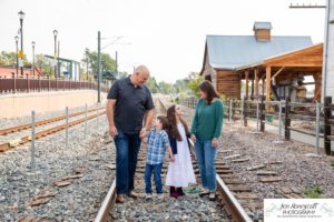 Littleton family photographer in Colorado Olde Town Arvada main street urban flour mill railroad tracks boy girl sister brother siblings mother father son daughter Halloween costume dinosaur zombie