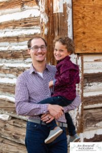 Littleton family photographer Hildebrand Ranch Colorado barn park foothills fall at sunset natural light photography mother father son little boy yellow trees twirling and kisses