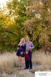 Littleton family photographer Hildebrand Ranch Colorado barn park foothills fall at sunset natural light photography mother father son little boy yellow trees twirling and kisses