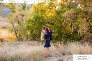 Littleton family photographer Hildebrand Ranch Colorado barn park foothills fall at sunset natural light photography mother father son little boy yellow trees twirling and kisses