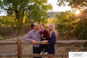 Littleton family photographer Hildebrand Ranch Colorado barn park foothills fall at sunset natural light photography mother father son little boy yellow trees twirling and kisses