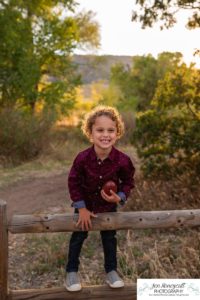 Littleton family photographer Hildebrand Ranch Colorado barn park foothills fall at sunset natural light photography mother father son little boy yellow trees twirling and kisses