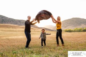 Littleton family photographer Hildebrand Ranch Colorado barn park foothills fall at sunset natural light photography mother father son little boy yellow trees twirling and kisses