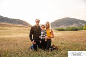 Littleton family photographer Hildebrand Ranch Colorado barn park foothills fall at sunset natural light photography mother father son little boy yellow trees twirling and kisses