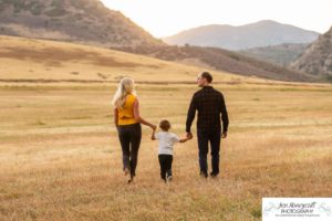 Littleton family photographer Hildebrand Ranch Colorado barn park foothills fall at sunset natural light photography mother father son little boy yellow trees twirling and kisses