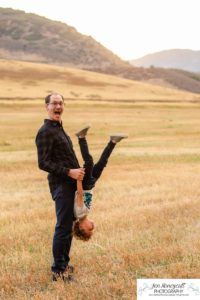 Littleton family photographer Hildebrand Ranch Colorado barn park foothills fall at sunset natural light photography mother father son little boy yellow trees twirling and kisses