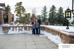 Littleton family photographer in Colorado at the Highlands Ranch Mansion in the snow boys brothers Christmas winter stone building iron gate