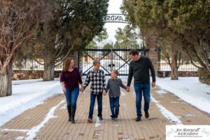 Littleton family photographer in Colorado at the Highlands Ranch Mansion in the snow boys brothers Christmas winter stone building iron gate