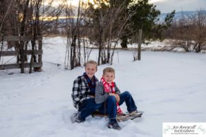 Littleton family photographer in Colorado at the Highlands Ranch Mansion in the snow boys brothers Christmas winter stone building iron gate