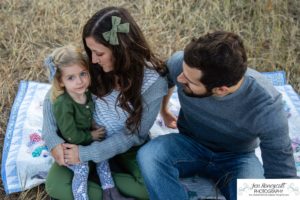 Littleton family photographer South Valley Open Space park Ken Caryl Colorado red rocks daughter little girl mother father guided pose snuggles sunset photography playful real moments