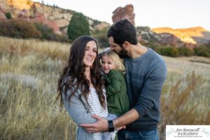 Littleton family photographer South Valley Open Space park Ken Caryl Colorado red rocks daughter little girl mother father guided pose snuggles sunset photography playful real moments