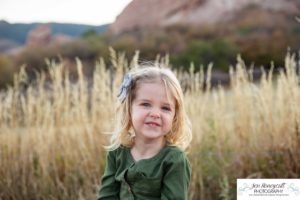 Littleton family photographer South Valley Open Space park Ken Caryl Colorado red rocks daughter little girl mother father guided pose snuggles sunset photography playful real moments