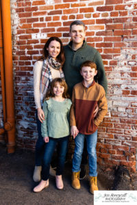 Littleton family photographer siblings urban snow pine trees brick walls brother sister sunset photography historic downtown winter coats