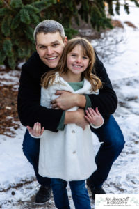 Littleton family photographer siblings urban snow pine trees brick walls brother sister sunset photography historic downtown winter coats
