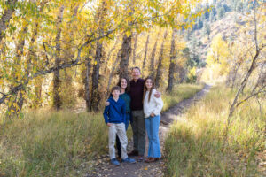 Littleton family photographer Lair O' the Bear park in Morrison Colorado yellow fall leaves trees mother father son daughter brother sister photography river bridge
