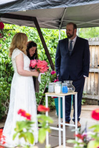 Littleton wedding photographer Colorado photography backyard ceremony flowers homemade arch kids family rain storm severe weather vows bride and groom