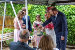 Littleton wedding photographer Colorado photography backyard ceremony flowers homemade arch kids family rain storm severe weather vows bride and groom