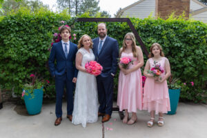 Littleton wedding photographer Colorado photography backyard ceremony flowers homemade arch kids family rain storm severe weather vows bride and groom