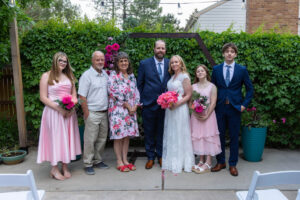 Littleton wedding photographer Colorado photography backyard ceremony flowers homemade arch kids family rain storm severe weather vows bride and groom