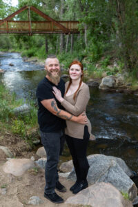 Littleton engagement photographer wedding marriage engaged couple in love future bride and groom Morrison park river water red rocks Mt. Falcon photography Colorado Wisconsin ring summer