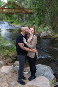 Littleton engagement photographer wedding marriage engaged couple in love future bride and groom Morrison park river water red rocks Mt. Falcon photography Colorado Wisconsin ring summer