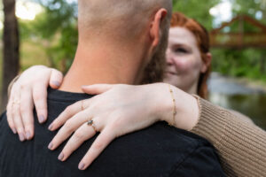 Littleton engagement photographer wedding marriage engaged couple in love future bride and groom Morrison park river water red rocks Mt. Falcon photography Colorado Wisconsin ring summer