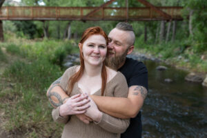 Littleton engagement photographer wedding marriage engaged couple in love future bride and groom Morrison park river water red rocks Mt. Falcon photography Colorado Wisconsin ring summer