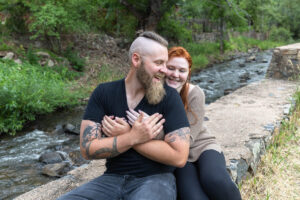 Littleton engagement photographer wedding marriage engaged couple in love future bride and groom Morrison park river water red rocks Mt. Falcon photography Colorado Wisconsin ring summer