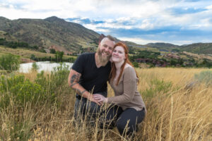 Littleton engagement photographer wedding marriage engaged couple in love future bride and groom Morrison park river water red rocks Mt. Falcon photography Colorado Wisconsin ring summer