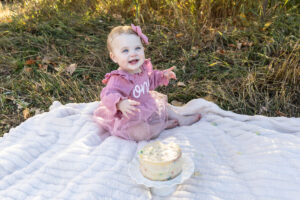 Littleton family photographer Fly'N B park Highlands Ranch Colorado one year old baby mother father child daughter little girl photography fall cake smash