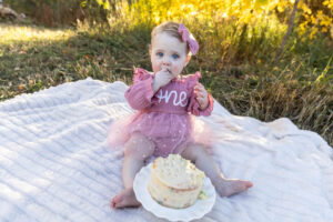 Littleton family photographer Fly'N B park Highlands Ranch Colorado one year old baby mother father child daughter little girl photography fall cake smash