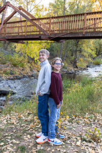 Littleton family photographer Morrison Park Colorado fall leaves color foothills photography brothers mother father sons bridge river